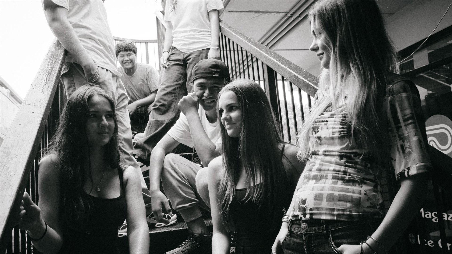 A group of young people sitting on stairs talking